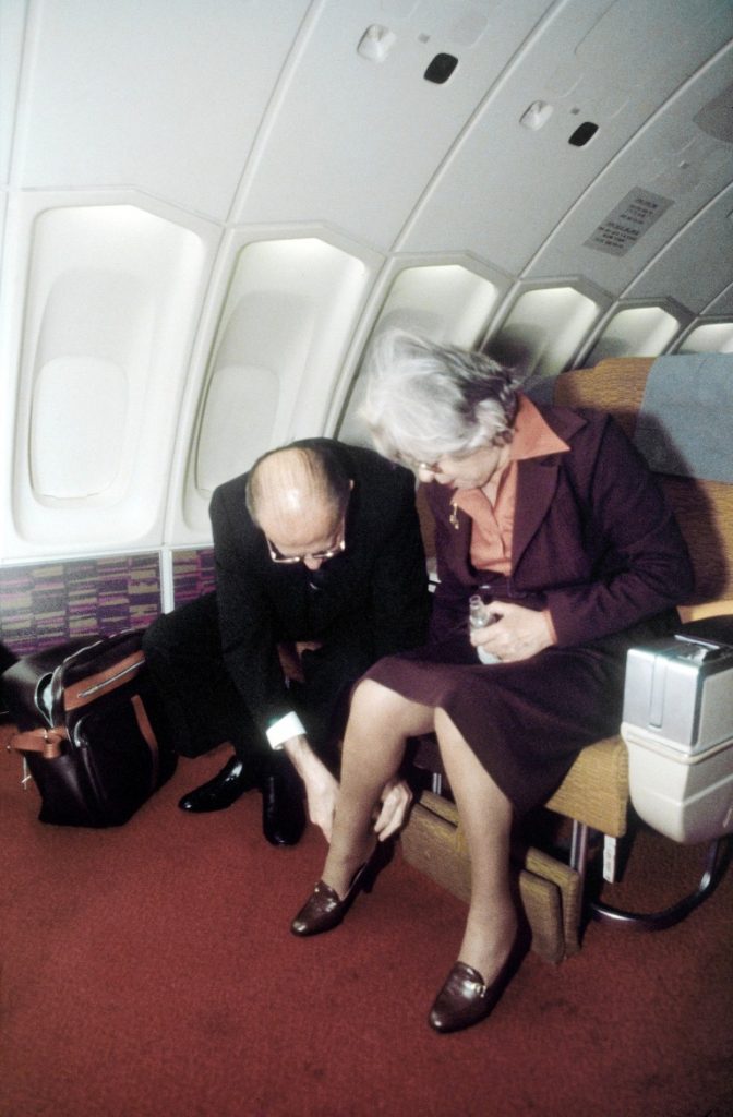 ראש הממשלה מנחם בגין מסייע פולה ודוד בן גוריון בצריף שדה בוקר לאשתו עליזה לנעול נעליים בטיסה לארה"ב / 1978 