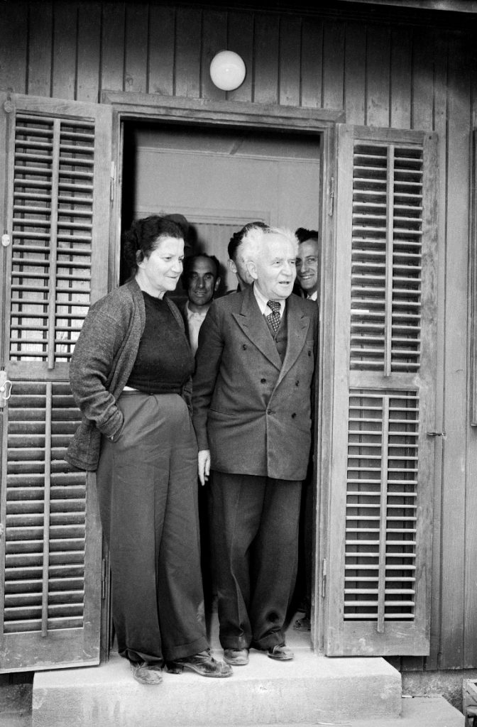 דוד בן גוריון ראש הממשלה שהתפטר עבר לגור ב קיבוץ שדה בוקר ב נגב דוד בן גוריון ו אשתו פולה עומדים ב פתח הצריף שלהם ב קיבוץ שדה בוקר DAVID BEN-GURION Prime.Min. with Paula Ben-Gurion After resignation,arriv.in Sde Boker. W/Paula.Hut.Dininghall Sde-Boker 19531214 PAULA BEN-GURION with BEN-GURION In Sde Boker Diningroom, after arrivall there , following BG's resignation Sde-Boker